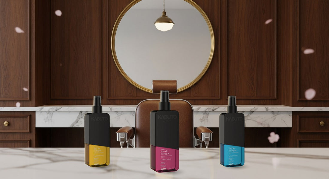 Drei Kabuto After-Shave-Colognes — Golden Botan, Sakura Mist und Azure Katana — auf der Marmor-Theke eines edlen Barbershops mit Kirschblüten